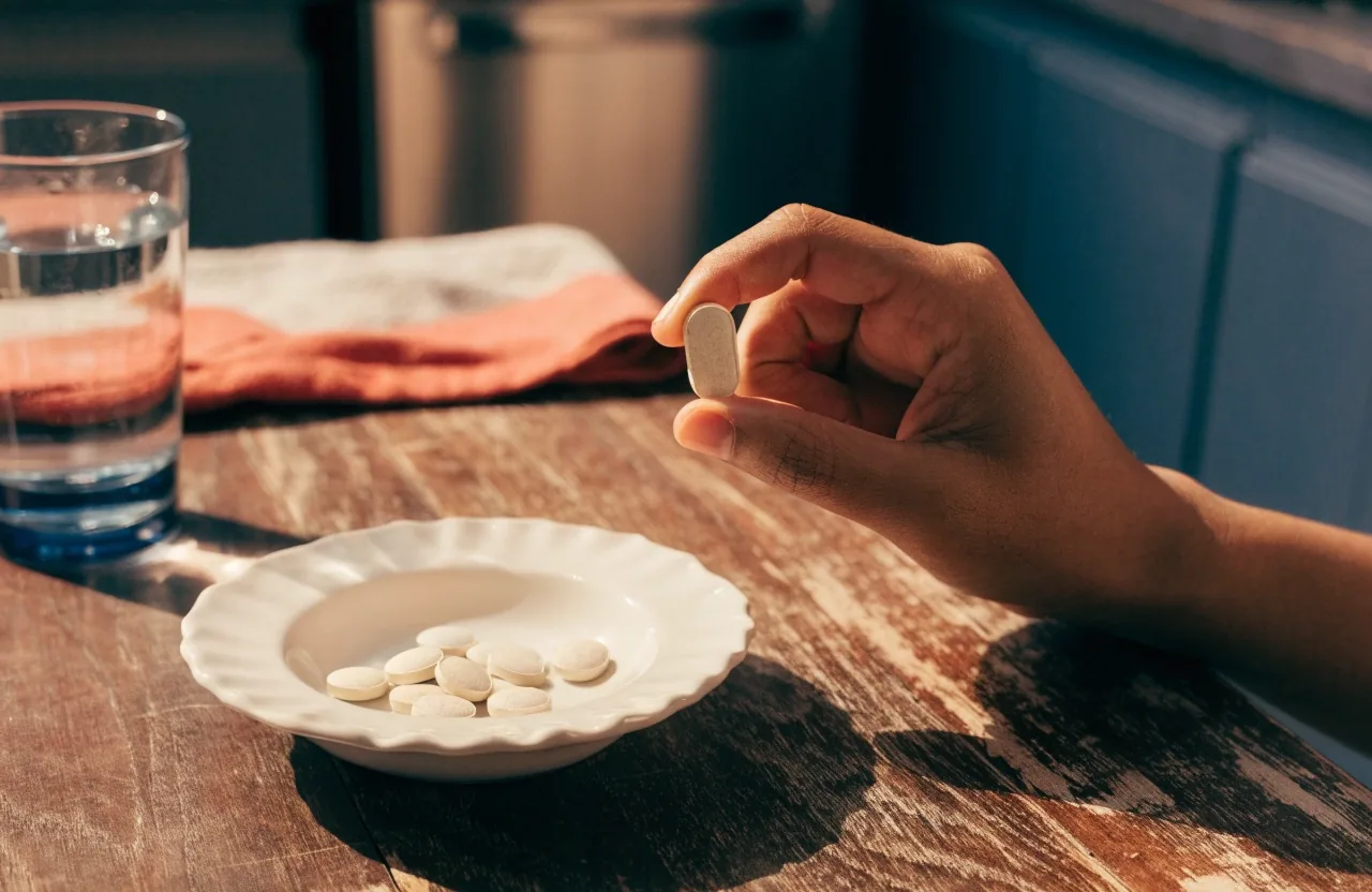 Macro view of a daily tablet split in half on a stone countertop in warm morning light